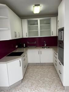 a kitchen with white cabinets and a sink and a microwave at La casa de Elisabeth in Nerja +67 photos