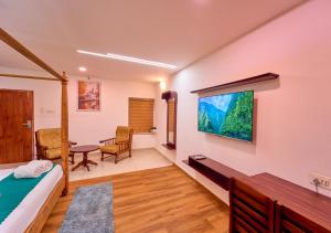 TV a/nebo společenská místnost v ubytování VOYE HOMES Signature Pool Resort Varkala , Just 950 m from Varkala Cliff and Beach