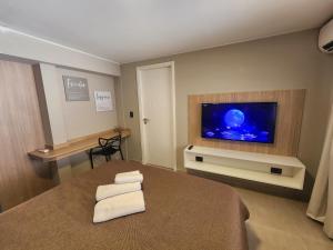 ein Schlafzimmer mit einem Bett und einem Flachbildfernseher in der Unterkunft Emilio Jofré II - Departamento céntrico y luminoso in Villa Marini