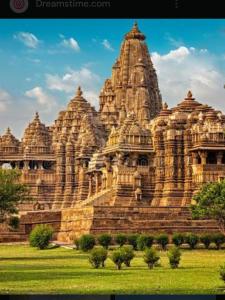 a large stone building with many towers on a field at Jyotis home stay Khajuraho in Khajurāho +14 photos
