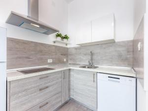 Una cocina con gabinetes blancos y un fregadero. en Apartment in Croatia by the Seafront, en Dramalj