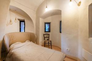 Pino TorineseにあるTorre di Montosoloのベッドと椅子のある寝室