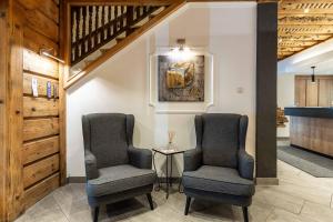 two chairs and a table in a room at Hotel Post by keyone in Bad Mitterndorf