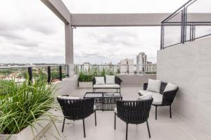 a patio with chairs and a table on a balcony at Luxe 2 Bedroom Apt In The Heart Of Villa Morra in Asuncion