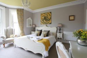1 dormitorio con 1 cama blanca, mesa y sillas en Brindleys, en Bath
