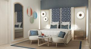 a bedroom with a bed and a chair and a table at Almar Timi Ama Resort & Spa in Villasimius