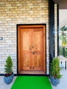 una porta in legno su una casa con un prato verde di Happy Hampi Home a Hospet
