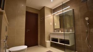 a bathroom with a shower and a toilet and a sink at Tulip Star Hawana in Salalah