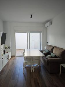 a living room with a table and a couch at Apartamento de dos habitaciones in Barbate