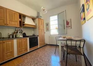 a kitchen with wooden cabinets and a table and chairs at Casa Flora in Finale Ligure