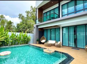a swimming pool in front of a house at Stay Tuned Pool Villa in Pattaya in Ban Huai Yai