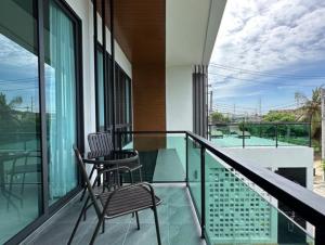 a balcony with two chairs and a table at Stay Tuned Pool Villa in Pattaya in Ban Huai Yai