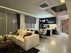 a living room with a white couch and a kitchen at Stay Tuned Pool Villa in Pattaya in Ban Huai Yai