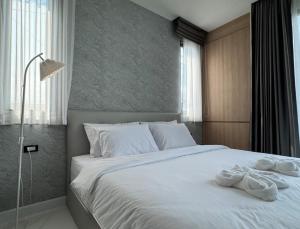 a bedroom with a large white bed with towels on it at Stay Tuned Pool Villa in Pattaya in Ban Huai Yai +38 photos