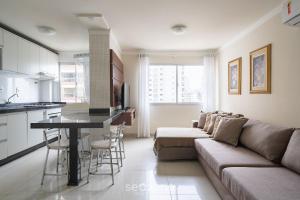 a living room with a couch and a table at Aptos a 2min da praia Balneário Camboriú/SC - EAC in Balneário Camboriú