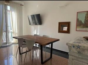 a dining room with a wooden table and chairs at Casa Flora in Finale Ligure