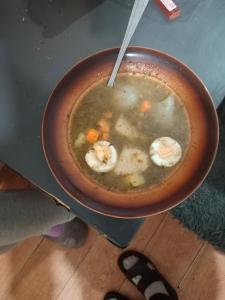 Eine Person hält eine Schüssel mit Meeresfrüchtesuppe. in der Unterkunft Villa na Krótkiej in Sulęcin