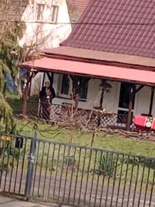 Ein Mann steht auf der Veranda eines Hauses in der Unterkunft Villa na Krótkiej in Sulęcin
