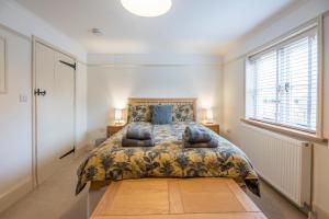 a bedroom with a bed and a large window at Kiln House, Snape Maltings in Snape