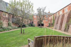 a park with a bench in front of a building at Kiln House, Snape Maltings in Snape