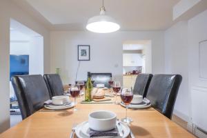 a dining room table with chairs and wine glasses at Kiln House, Snape Maltings in Snape