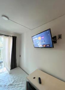 a room with a bed and a flat screen tv on the wall at Flamingo 38 en SúperAnfitrión Coyoacán in Mexico City