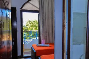 a room with a window and a table with a pink bow at BAYT ZAINA - Nubian hospitality house in Aswan