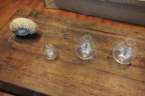 four glass jars sitting on a wooden table at Hotel Santa Maria in Saint-Florent
