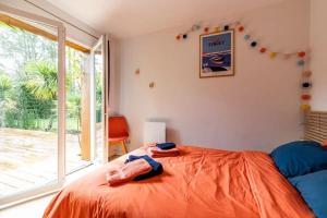 a bedroom with a bed and a large window at Villa Titoune, le charme du Coeur de Bassin, à 2 familles ou entre amis in Lanton