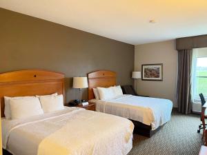 a hotel room with two beds and a window at SureStay by Best Western Forsyth Decatur in Forsyth +6 photos