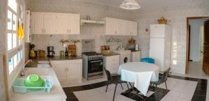 a kitchen with white cabinets and a table and a table and a table at Dar louzir à Tazarka in Tazarka
