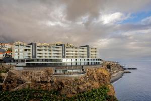 ein Gebäude auf einer Klippe am Meer in der Unterkunft Peace Haven III in Câmara de Lobos