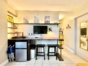 a room with a desk with a computer and stools at Sunset Studio Daytona Beachfront in Daytona Beach +7 photos