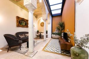 a living room with a couch and a tv at Teatro Suites Málaga in Málaga