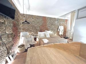 een slaapkamer met een stenen muur en een bed bij Super Galleria in Tuscania