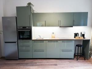 a kitchen with blue cabinets and a refrigerator at 70qm Apartment in Viersen zentral gelegen mit hohen Decken - BEUYS Apartments - Viersen in Viersen