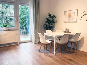 a dining room with a white table and chairs at 70qm Apartment in Viersen zentral gelegen mit hohen Decken - BEUYS Apartments - Viersen in Viersen