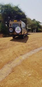 Una camioneta estacionada en un campo con un cartel en ella en Wildlife tour, en Arusha