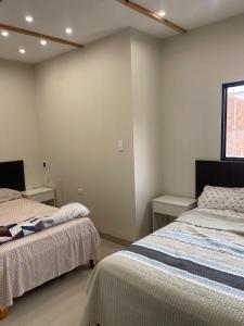 a bedroom with two beds and a window at Casa Apartament Paseo Del Mar in Chimbote