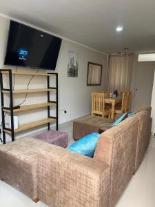a living room with a couch and a flat screen tv at Casa Apartament Paseo Del Mar in Chimbote