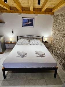 a bedroom with a bed with two pillows on it at House Kučija Old town Korčula in Korčula