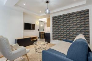 a living room with a blue couch and two chairs at Superb apartment in the heart of the peninsula - Air-conditioned in Lyon