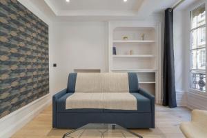 a living room with a blue chair and a table at Superb apartment in the heart of the peninsula - Air-conditioned in Lyon