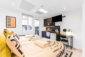 a bedroom with a large bed and a kitchen at Funky London Studio, Comfort Meets Style in London