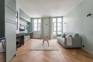 een woonkamer met een bank en een tafel bij Suite St Antoine 4 travelers in Lyon