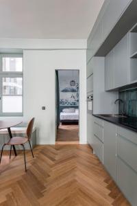 een keuken met witte kasten en een tafel en een stoel bij Suite St Antoine 4 travelers in Lyon