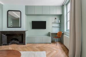 een woonkamer met televisie en open haard bij Suite St Antoine 4 travelers in Lyon +24 foto's