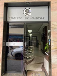 una entrada al concesionario de coches con un coche en la puerta en Apartamento Centro de São Lourenço - com vista para o parque das águas, en São Lourenço