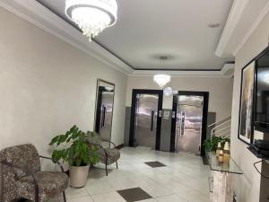 un vestíbulo con 2 sillas y una lámpara de araña en Apartamento Centro de São Lourenço - com vista para o parque das águas, en São Lourenço