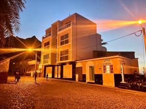 a street with a building and people walking down a street at Oásis de retour in Ponta do Sol